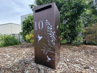 Medium free standing pillar Letterbox in Powder Coated aluminium. Unique Grevillea with Bees pattern on mailbox.